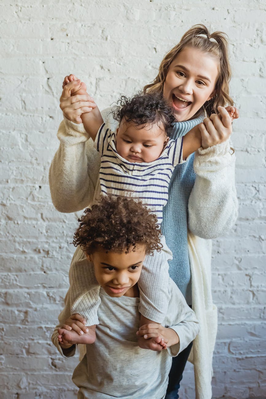 mother with black sons near brick white wall