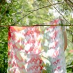 unrecognizable person behind colorful fabric